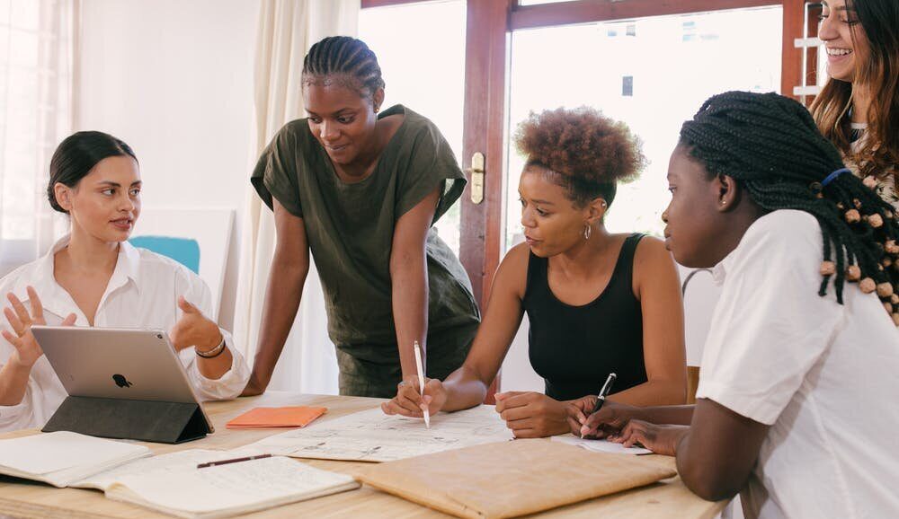 A group of people gathered around in a discussion