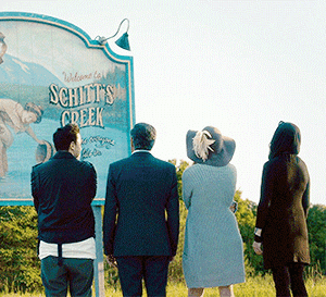 Gif of Schitts Creek family looking at the Schitts Creek sign