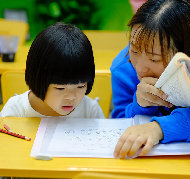Teacher and young student doing school work