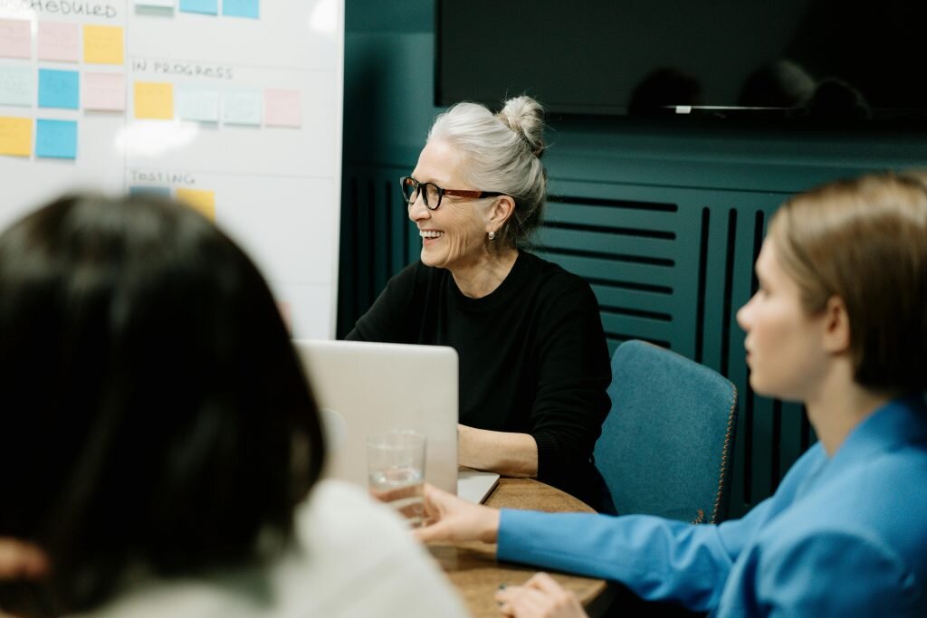 person sitting in a meeting smiling