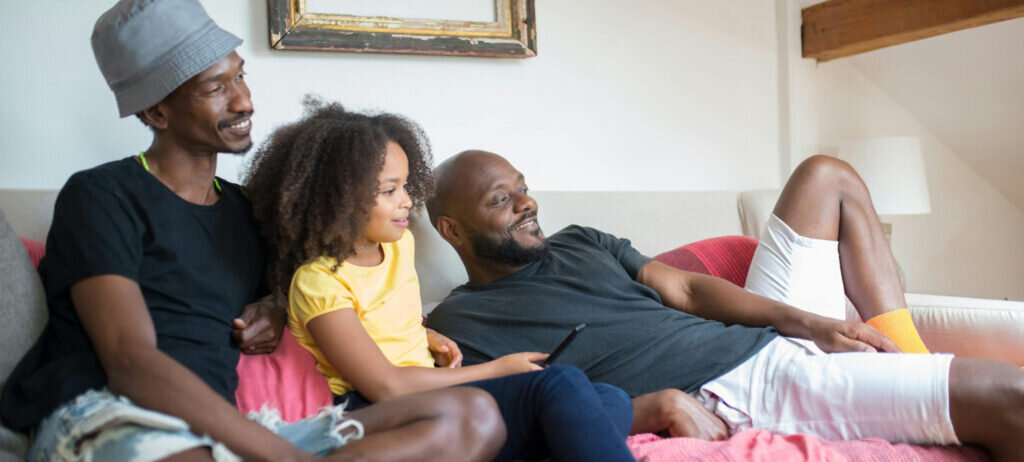 Two men and a young girl laughing