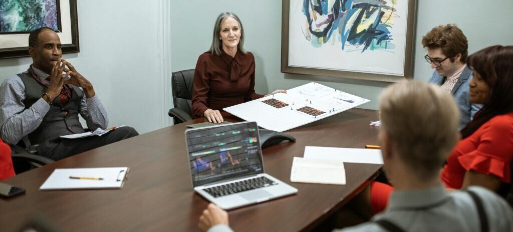 A group of professionals sit around a table in discussion