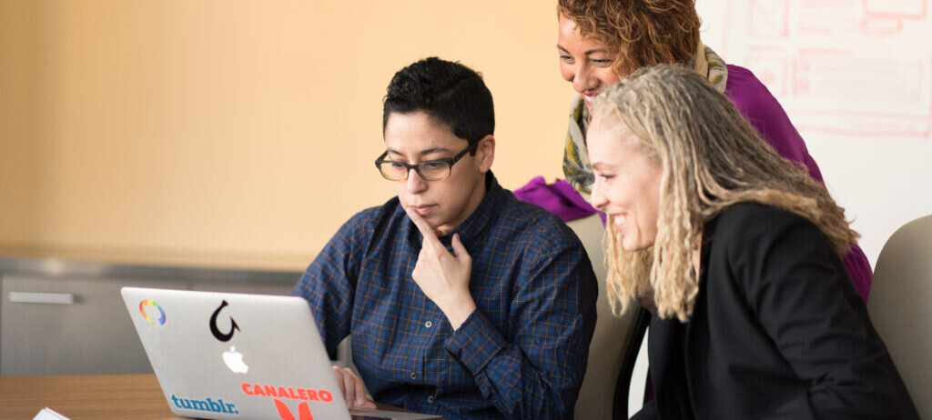 Three people looking at the computer